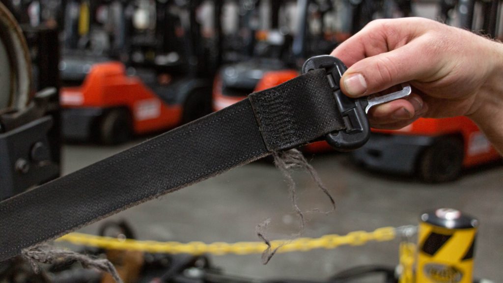 The seat belt of a forklift truck showing clear signs of wear